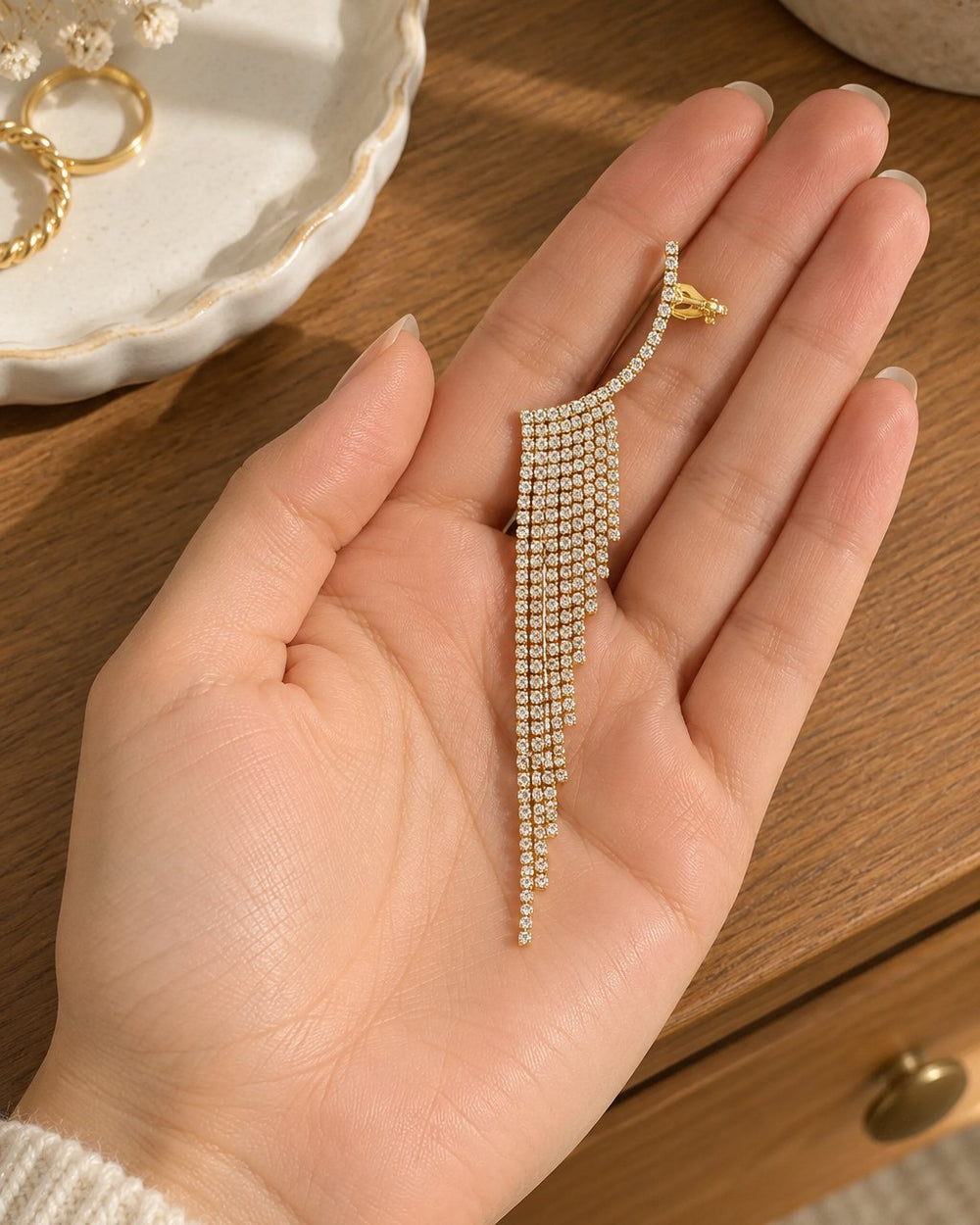 One ear climber lying on an open palm beside a small ring dish, showing its length