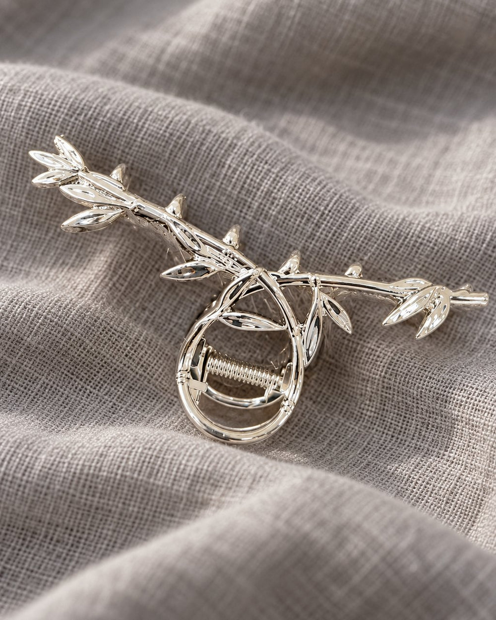 Close-up of the polished sculpted leaves and looped grip of the metal claw clip