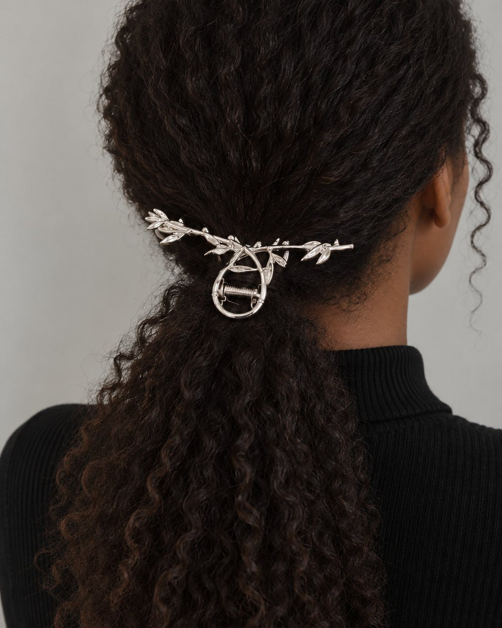 Back view of a low ponytail with the silver leaf claw clip clipped across it