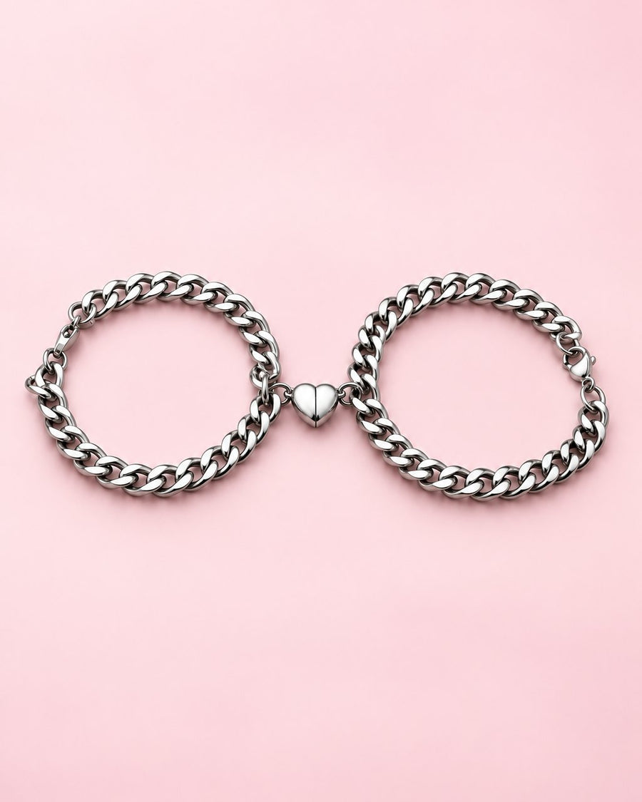 Pair of silver-tone curb chain bracelets with their magnetic heart halves joined in the middle