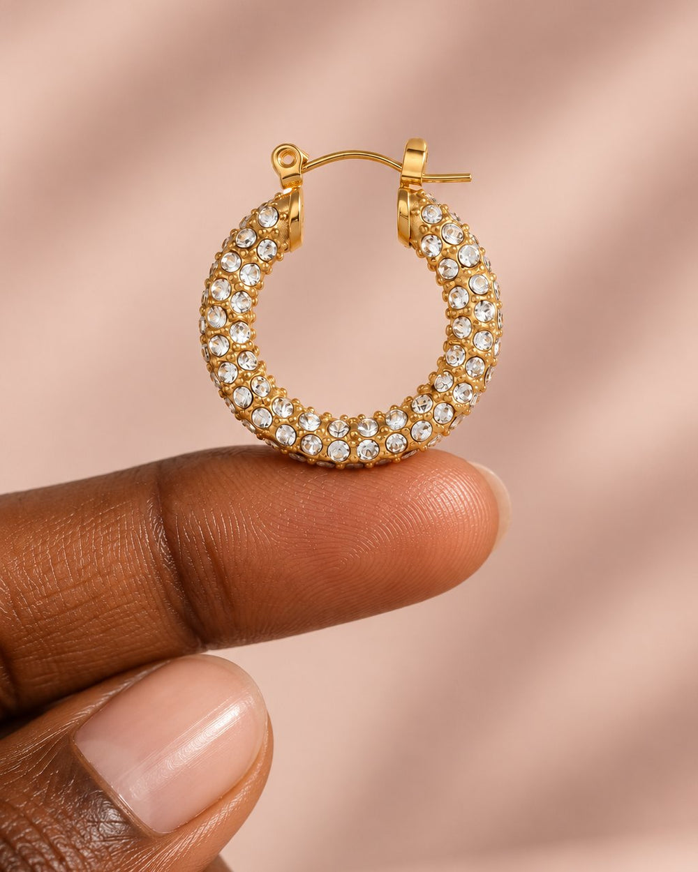 One 23 mm pavé hoop resting on a fingertip to show its size