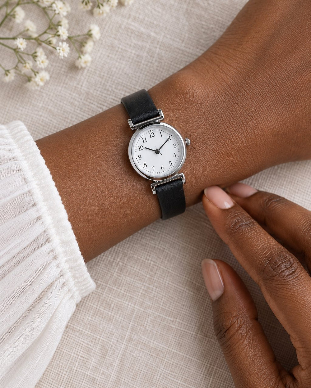 The petite watch on a slim wrist, its small round face narrower than the wrist