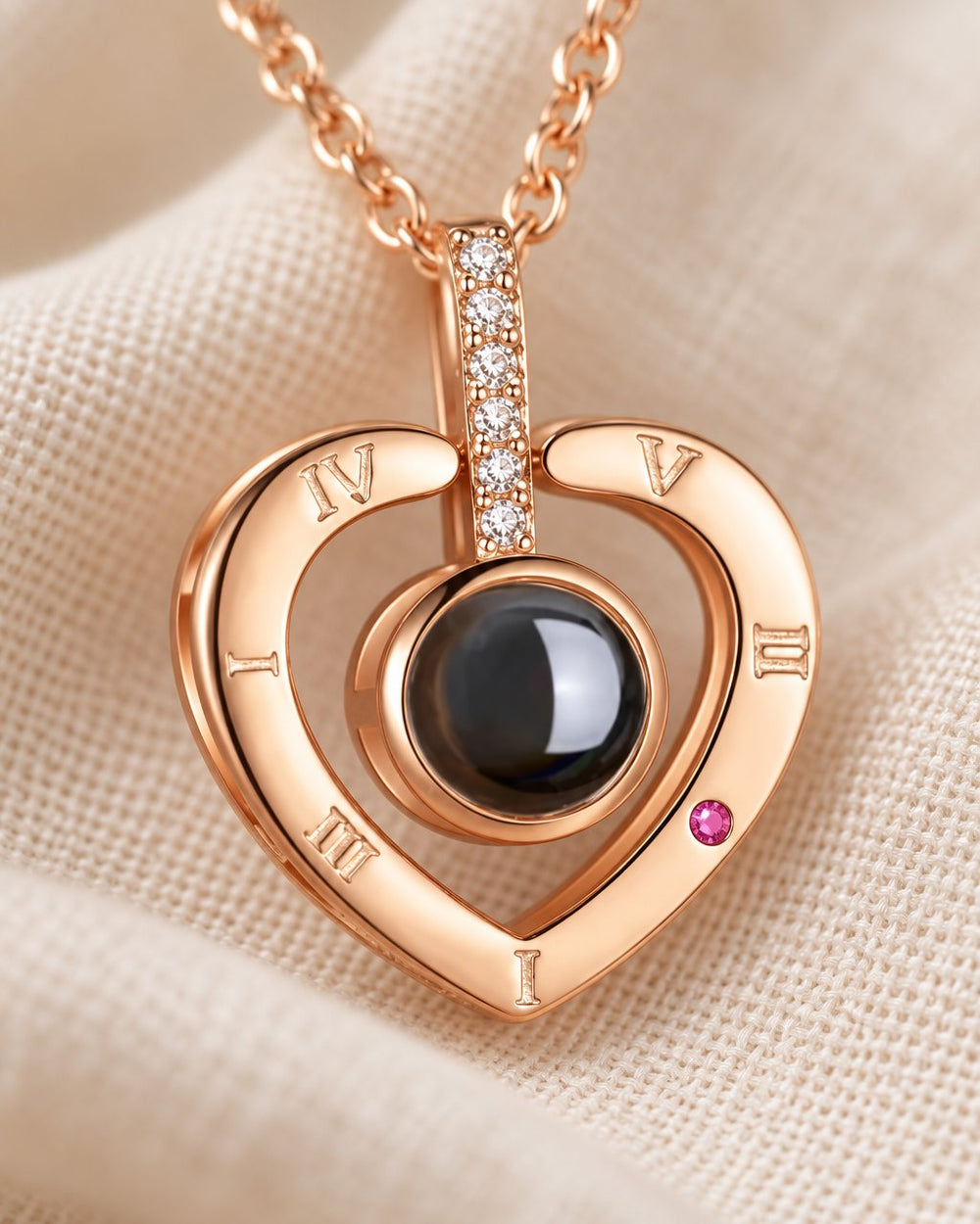 Close-up of the heart frame with roman numerals, the sparkly bail and the round black projection stone