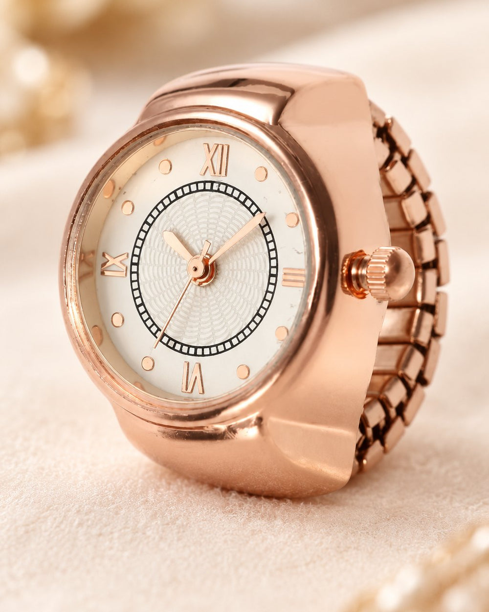 Close-up of the ring watch dial with Roman numerals, slim hands and the small crown at the side