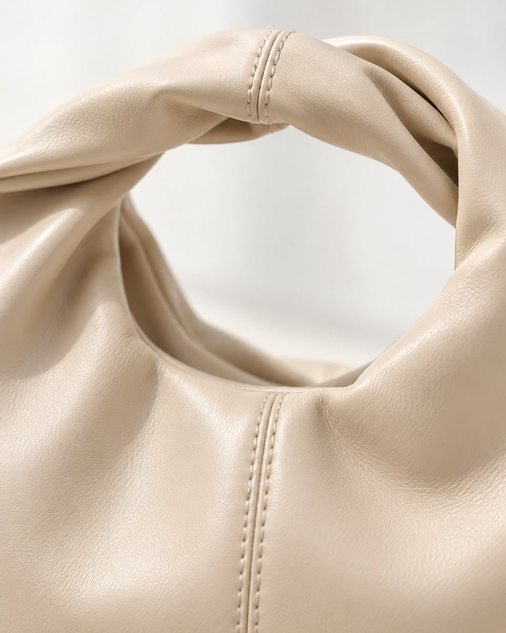 Close-up of the bag's twisted handle and soft, smooth finish