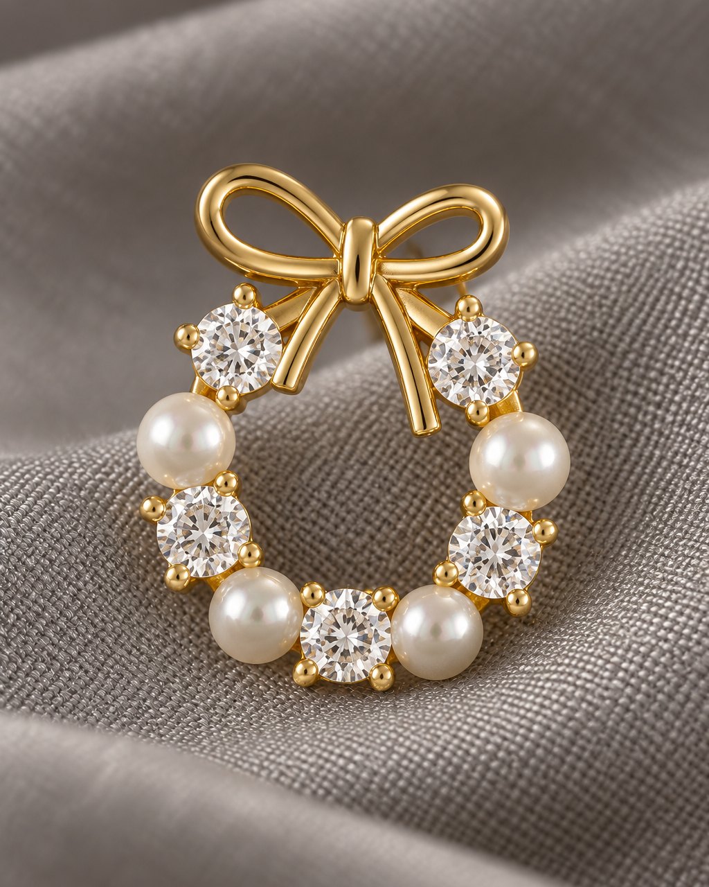 Close-up of the gold-tone bow, the claw-set clear stones and the round pearl-look beads