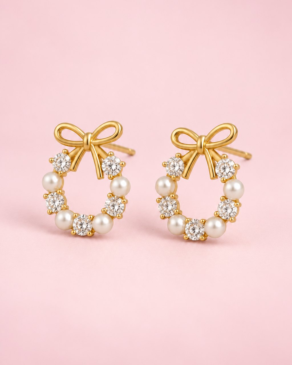 Pair of gold-tone bow studs, each on a small wreath of clear stones and pearl-look beads