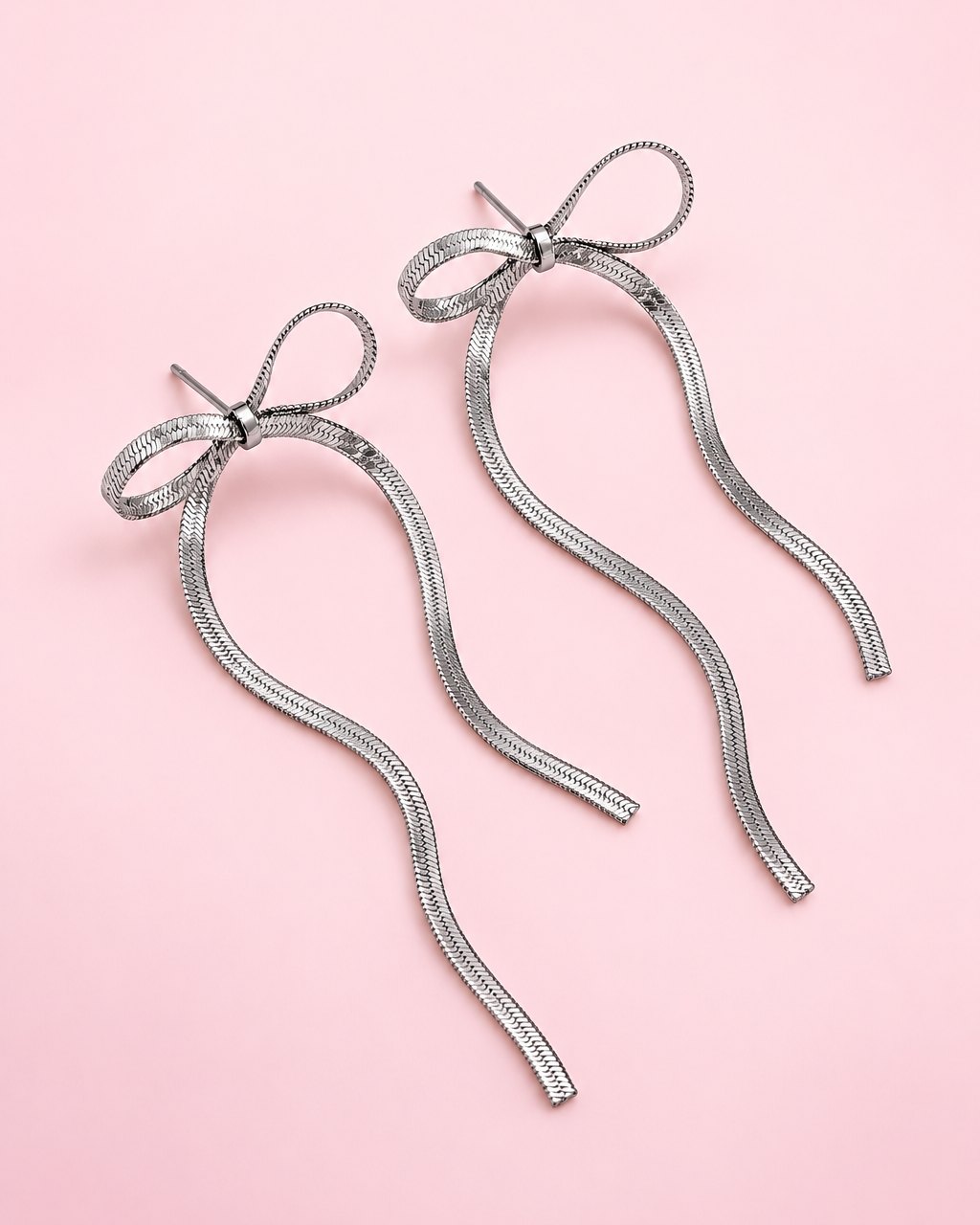 Silver-tone chain bow earrings with long, flat chain tails
