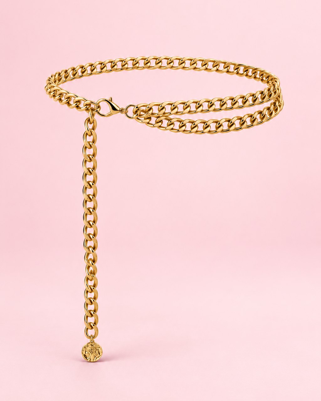 Gold-tone double curb chain belt laid in a loop with its long side drop