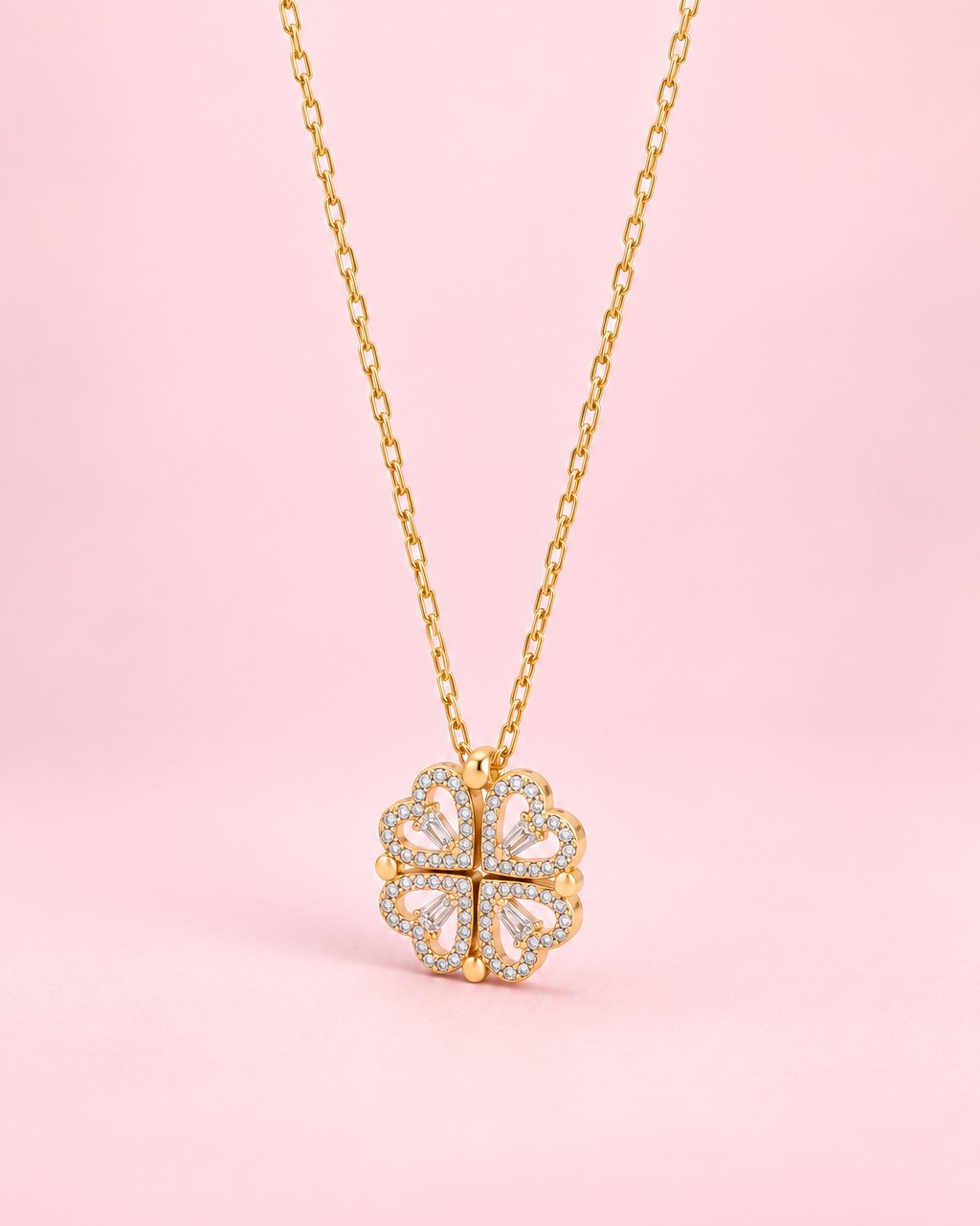 Gold-tone pendant of four stone-edged hearts folded into a clover, on a fine chain