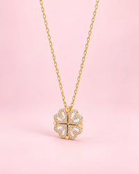 Gold-tone pendant of four stone-edged hearts folded into a clover, on a fine chain