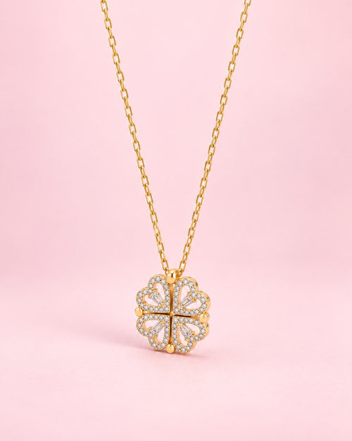 Gold-tone pendant of four stone-edged hearts folded into a clover, on a fine chain