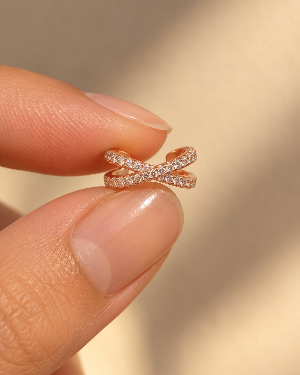The ear cuff resting on a fingertip to show how small it is