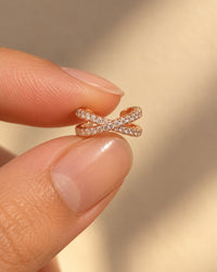 The ear cuff resting on a fingertip to show how small it is