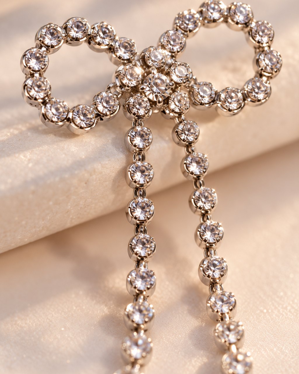Close-up of the clear stones tracing the bow's loops and the clustered centre knot