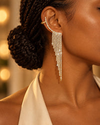 Side view of an ear wearing the gold-tone climber, rhinestones running up the rim and a fringe hanging from the lobe