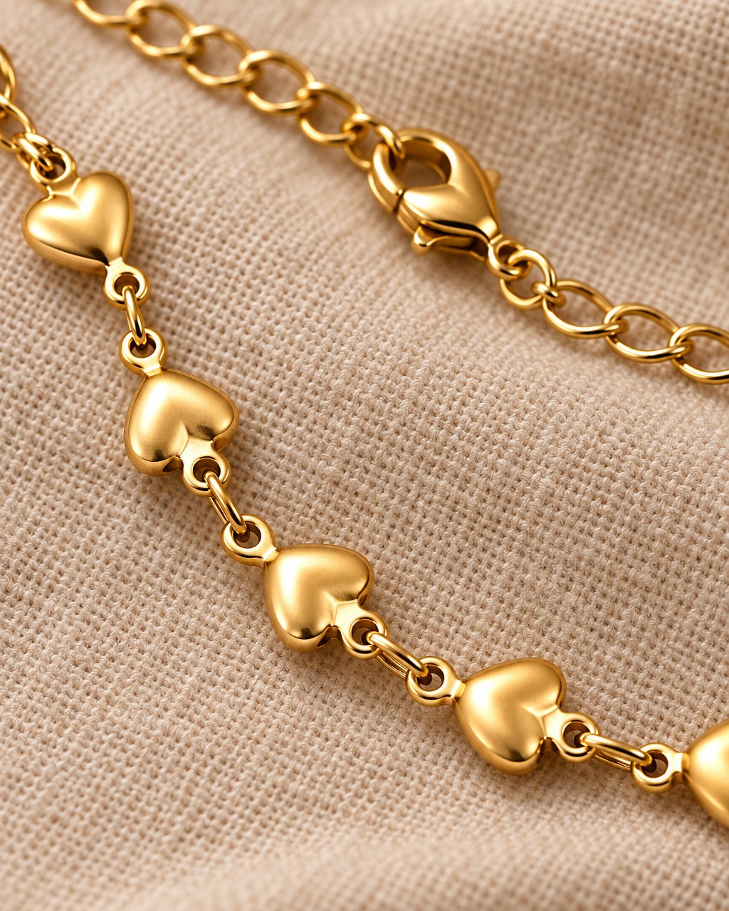 Close-up of the smooth puffed hearts, the small links and the lobster clasp