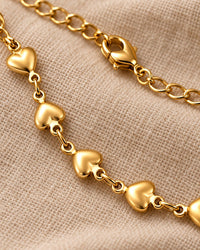 Close-up of the smooth puffed hearts, the small links and the lobster clasp