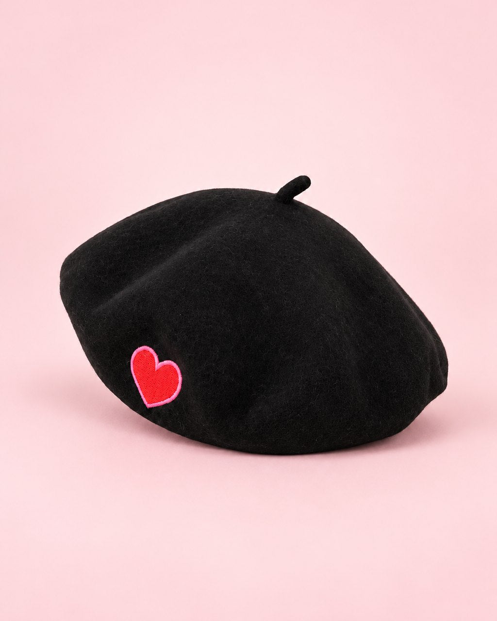 Black beret with a small embroidered red heart on the side