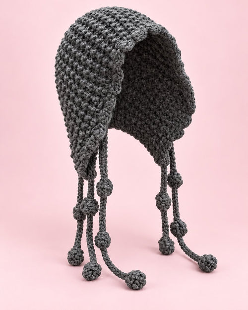 Grey chunky hand-knit bonnet with a wavy edge and long knotted ties