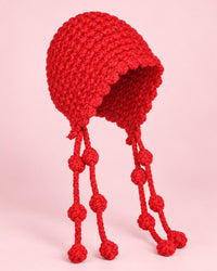 Red chunky hand-knit bonnet with long knotted ties