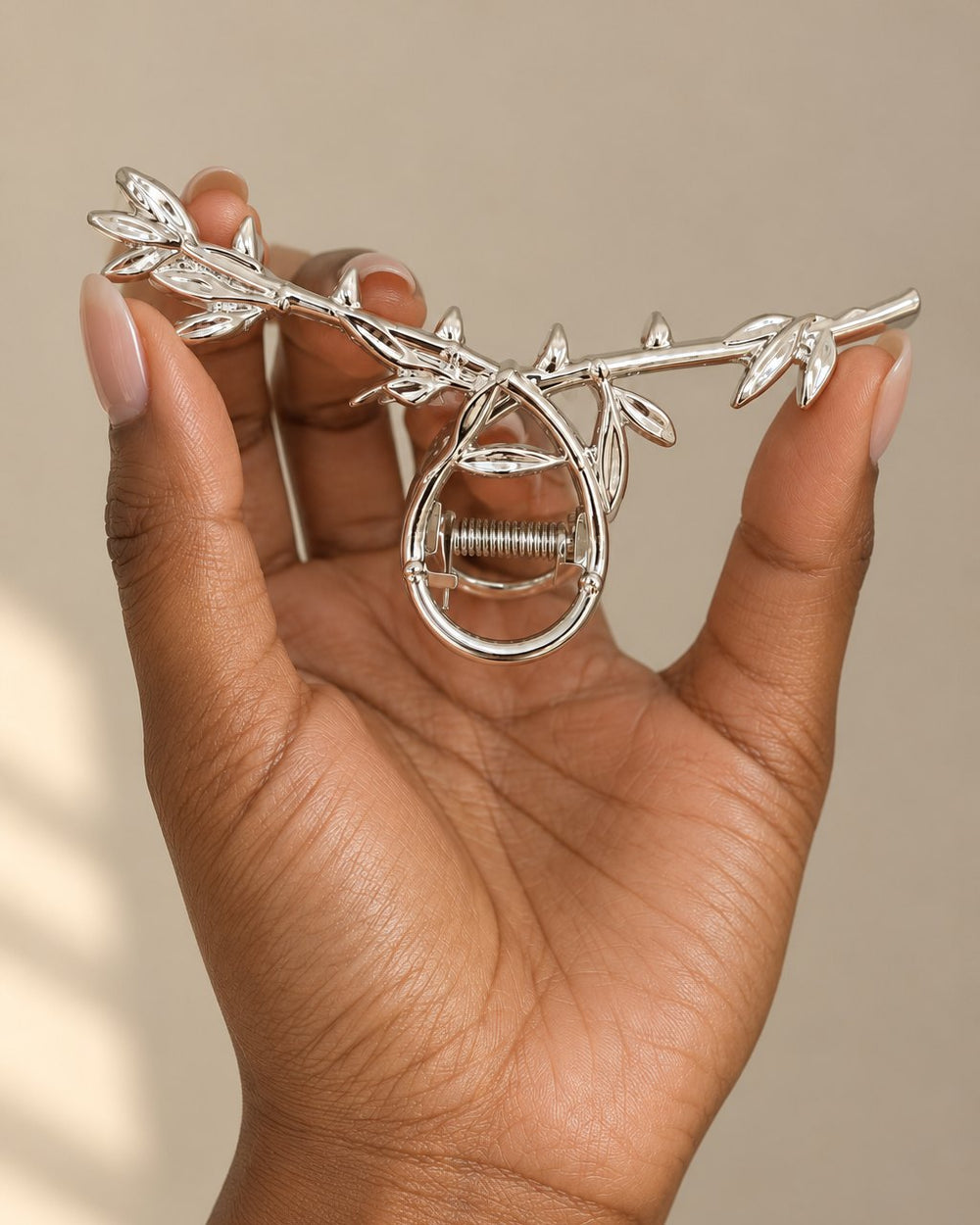 The leaf claw clip held between two fingers, about the length of a hand