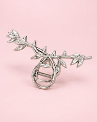 Silver-tone metal claw clip shaped like a twisting vine of leaves
