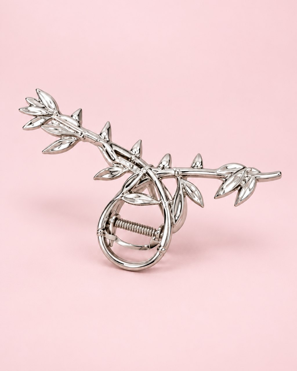Silver-tone metal claw clip shaped like a twisting vine of leaves