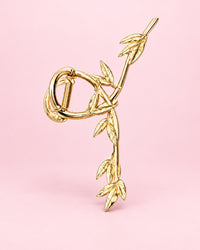 Gold-tone metal claw clip shaped like a twisting vine of leaves