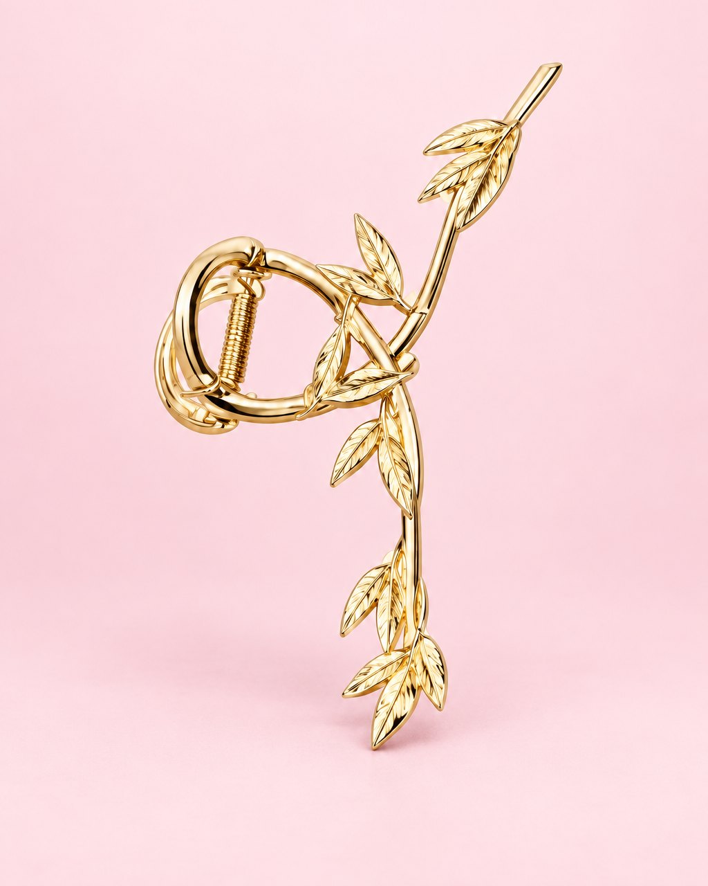 Gold-tone metal claw clip shaped like a twisting vine of leaves
