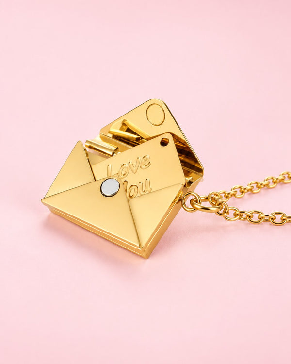 Gold-tone envelope pendant, open to show a tiny card engraved 'Love You', on a gold-tone chain