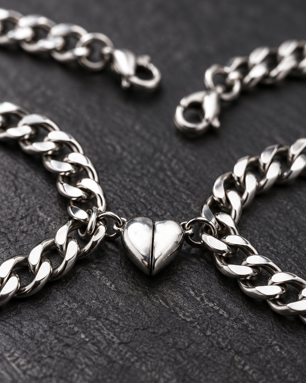 Close-up of the two polished heart halves clicked together between the curb chain links