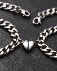 Close-up of the two polished heart halves clicked together between the curb chain links