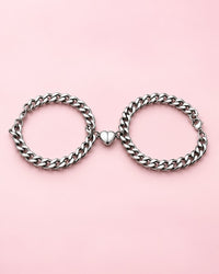 Pair of silver-tone curb chain bracelets with their magnetic heart halves joined in the middle