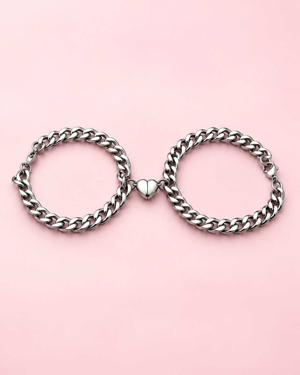 Pair of silver-tone curb chain bracelets with their magnetic heart halves joined in the middle