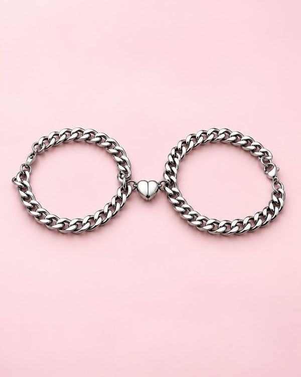 Pair of silver-tone curb chain bracelets with their magnetic heart halves joined in the middle