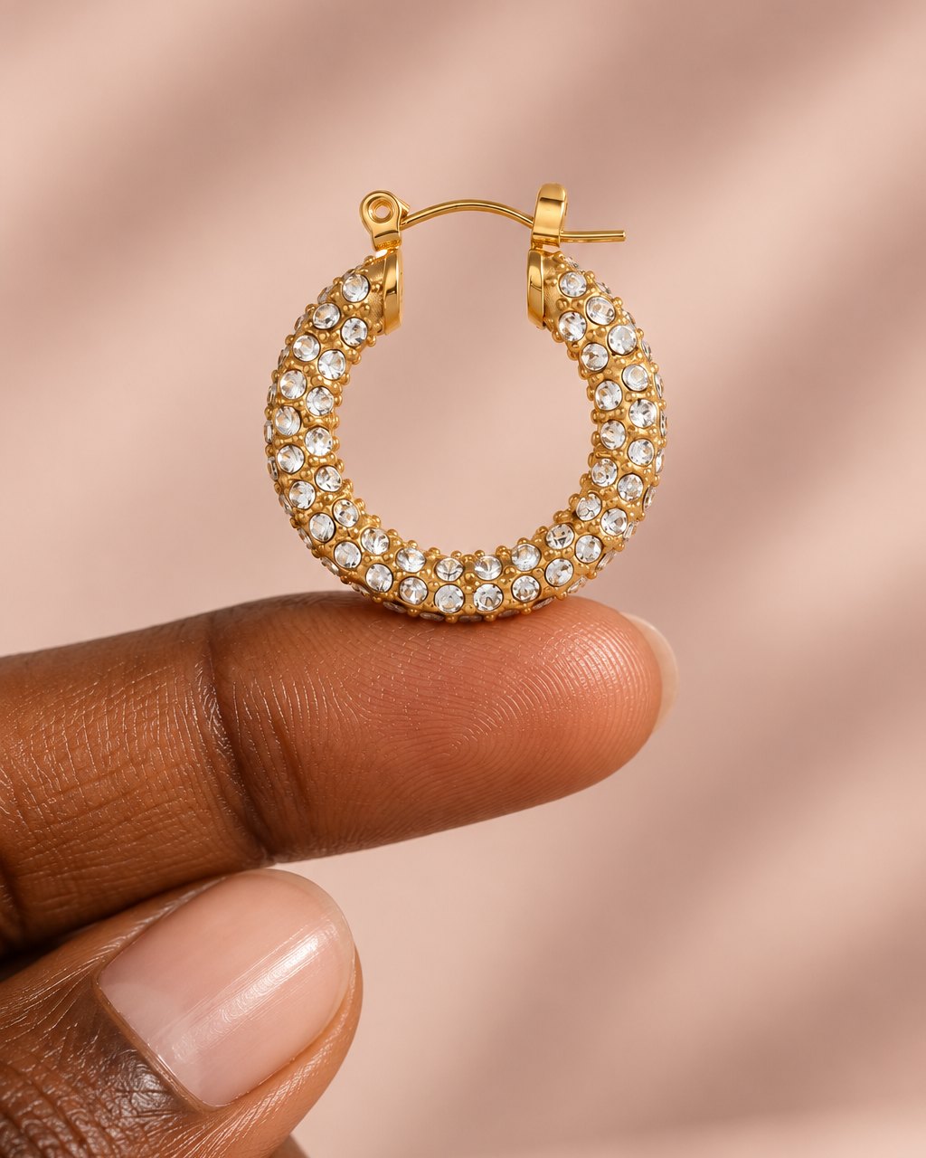 One 23 mm pavé hoop resting on a fingertip to show its size