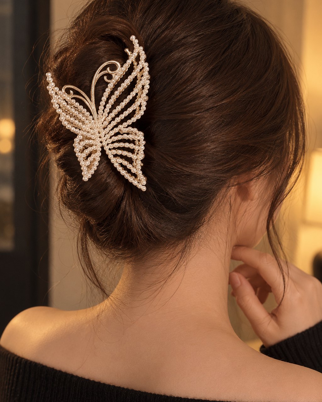 Back view of a woman's twisted updo held by the pearl butterfly claw clip, wings fanned open