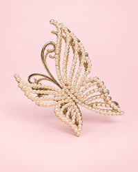 Gold-tone butterfly claw clip with wings beaded in small faux pearls