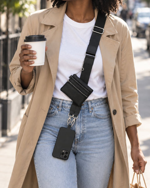 Woman walking with a coffee, the black strap worn crossbody and her phone hanging at her hip