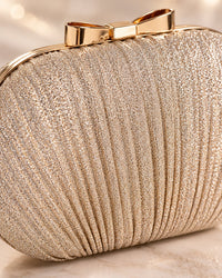 Close-up of the clutch's fine shimmering pleats, gold-tone frame and bow