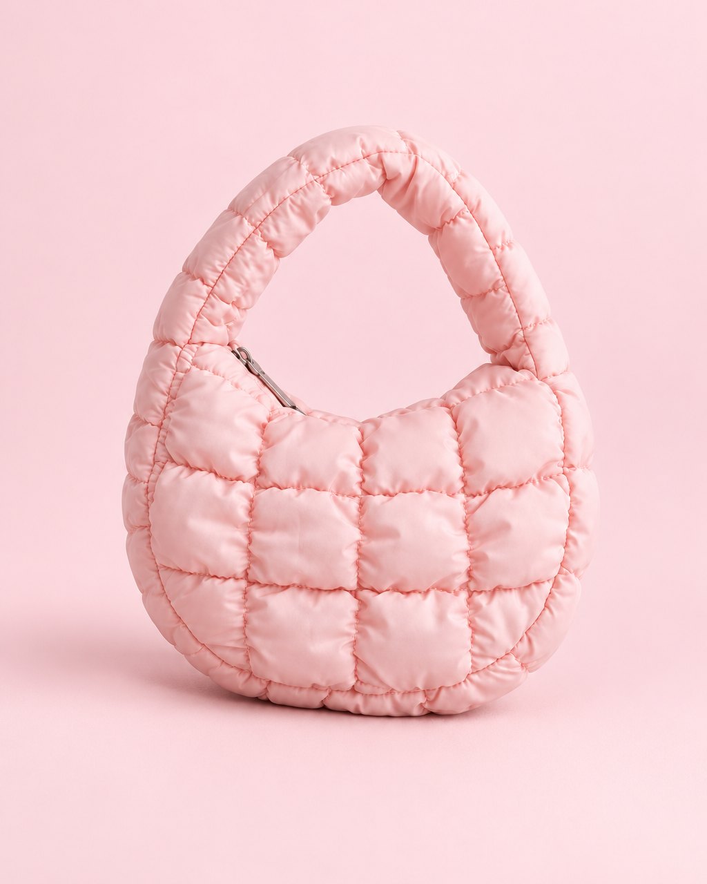 Pink puffy quilted mini bag with a short top handle