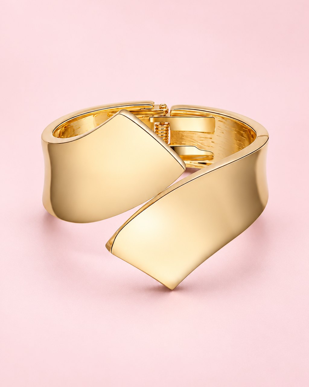 High-shine gold-tone cuff with two sculpted ends crossing over each other