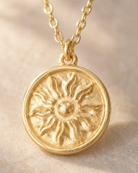 Close-up of the embossed sun with wavy rays and a raised rim