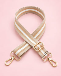 Beige striped webbing bag strap with gold-tone clips and slider, coiled