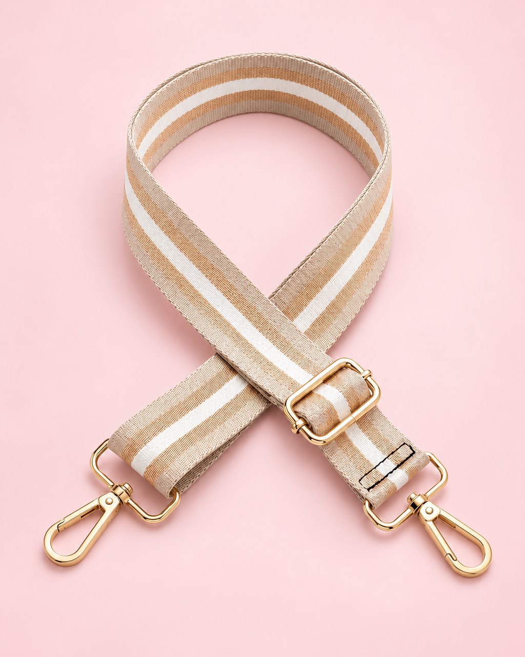 Beige striped webbing bag strap with gold-tone clips and slider, coiled