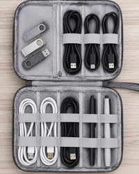 Open pouch lying flat: a mesh pocket and elastic loops holding coiled cables, with rows of loops below