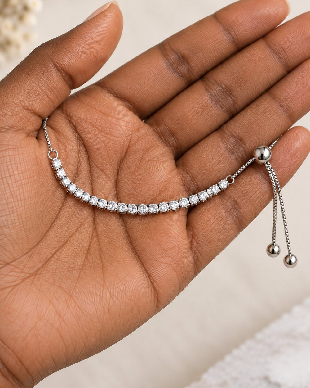 The bracelet resting in a loose loop on an open palm, its 8 cm row of stones across the palm