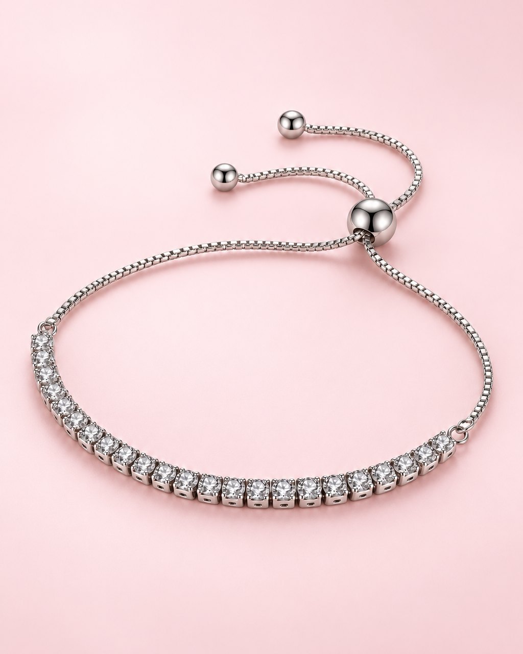 Silver-tone bracelet with a row of clear stones, a box chain and a round slider bead