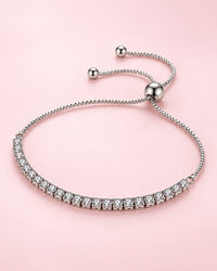 Silver-tone bracelet with a row of clear stones, a box chain and a round slider bead
